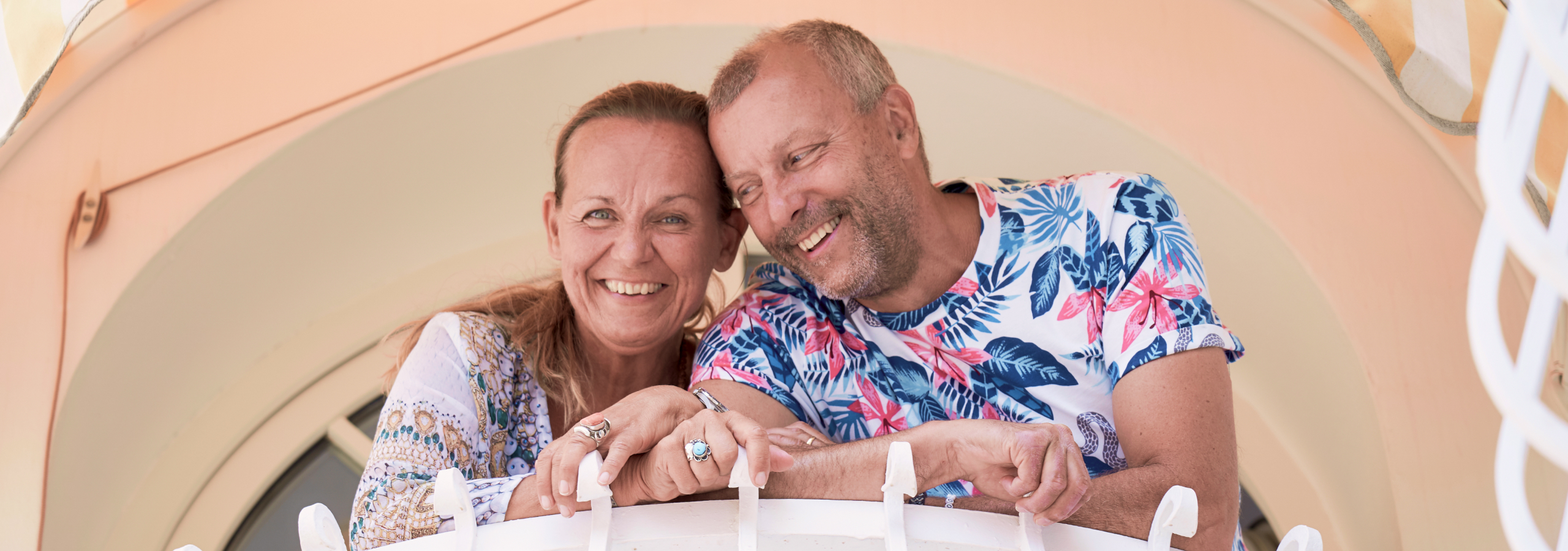 Elisabeth Engqvist og Anders Engqvist fra MediYoga står tæt sammen på en altan og smiler.